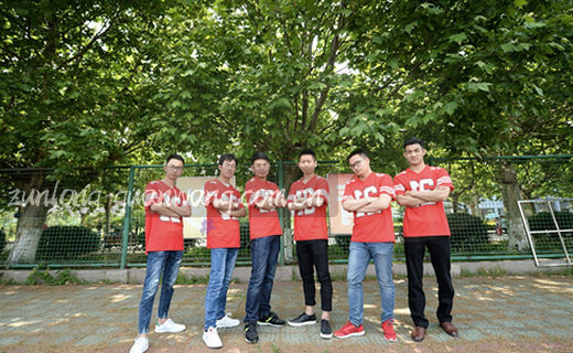 一位老人举着放大镜，在灯下仔细读报纸。
